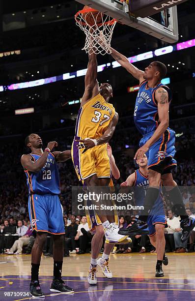 Ron Artest of the Los Angeles Lakers goes up for a dunk between Jeff Green and Thabo Sefolosha of the Oklahoma City Thunder in the second quarter...