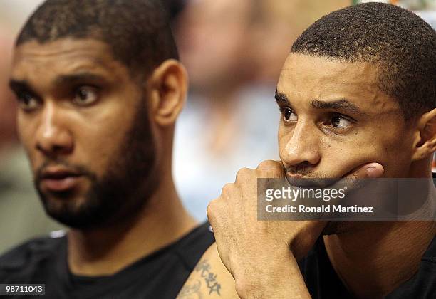 Tim Duncan and George Hill of the San Antonio Spurs sit on the bench during a 103-81 loss to the Dallas Mavericks in Game Five of the Western...