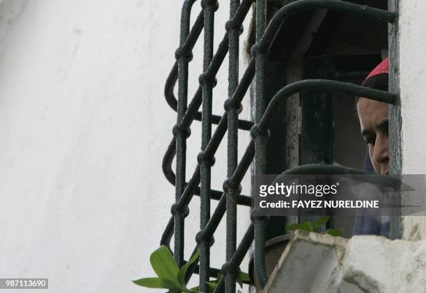 An Algerian woman looks on her house's window in the historical Casbah distrisct in Algiers City 25 May 2006. Once a sparkling white medina, or...