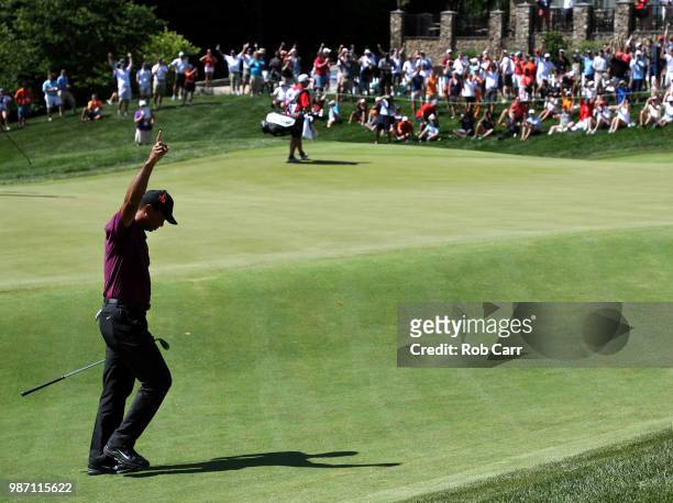 Tiger Woods reacts after chipping in for birdie on the 18th hole during the second round of the Quicken Loans National at TPC Potomac on June 29,...