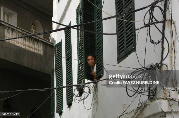 Woman looks from her house's window in the historical Casbah district in Algiers 25 May 2006. Once a sparkling white medina, or Islamic city, perched...