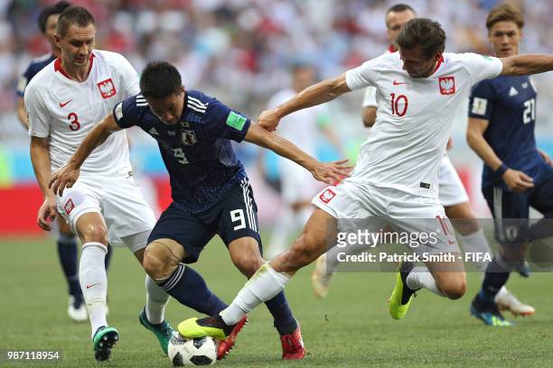 Shinji Okazaki of Japan dribbles past Grzegorz Krychowiak of Poland during the 2018 FIFA World Cup Russia group H match between Japan and Poland at...