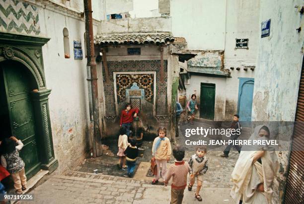 Une femme voilée passe à côté des enfants qui jouent en avril 1975 dans une rue de la Casbah d'Alger. La Casbah d'Alger, coeur historique de la...