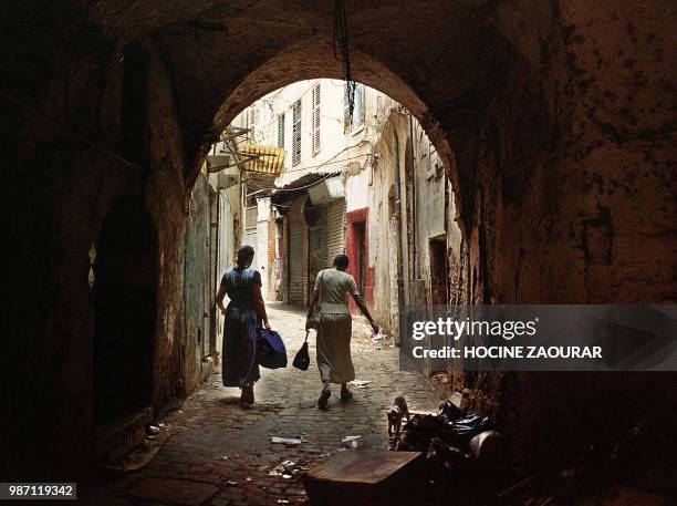 Deux femmes portent leurs provisions dans la casbah d'Alger, le 31 juillet 2001. AFP PHOTO HOCINE