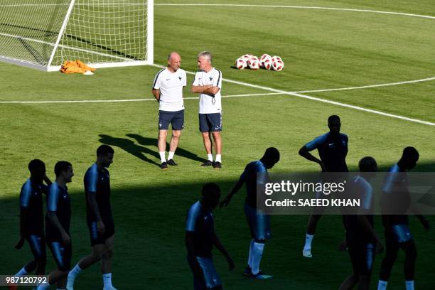 France's head coach Didier Deschamps and assistant coach Guy Stephan look at their football players as they lead a training session at the Tsentralny...