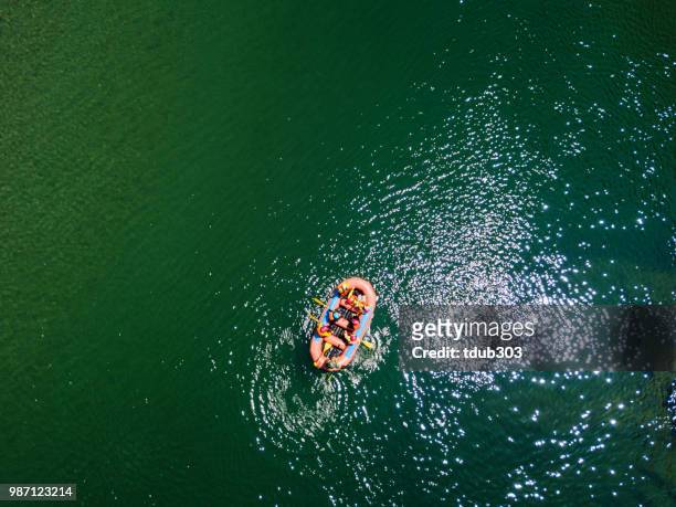 vista aérea de un grupo de hombres y mujeres rafting en un río tranquilo - bote neumático fotografías e imágenes de stock