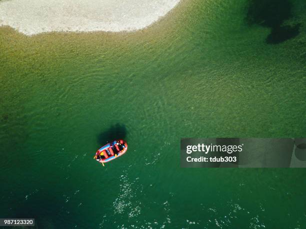 aerial view of a group men and women rafting in a calm river - whitewater rafting stock pictures, royalty-free photos & images