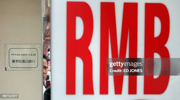 HongKong-China-US-economy-currency-trading-finance,FOCUS by Peter Brieger A man walking down a street is reflected in the frame of a Chinese yuan, or...