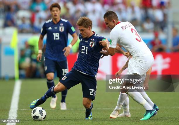 Gotoku Sakai of Japan is challenged by Artur Jedrzejczyk of Poland during the 2018 FIFA World Cup Russia group H match between Japan and Poland at...