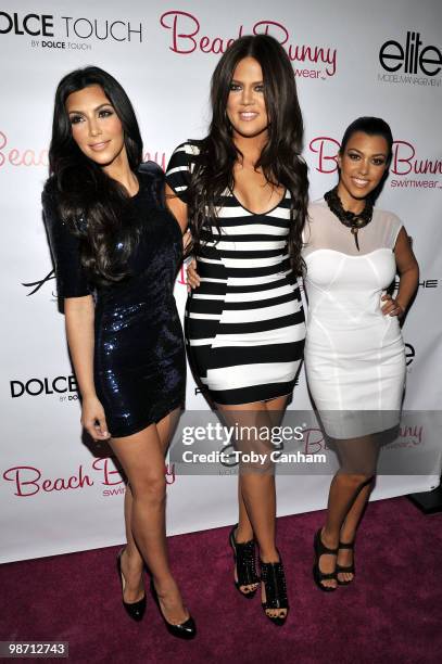 Kim Kardashian, Khloe Kardashian and Kourtney Kardashian pose for a picture at the Beach Bunny Swimwear's grand opening party on April 27, 2010 in...