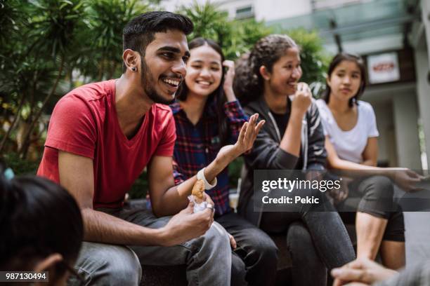 gruppe von studenten scherzen und einander kennenlernen - indian subcontinent ethnicity stock-fotos und bilder