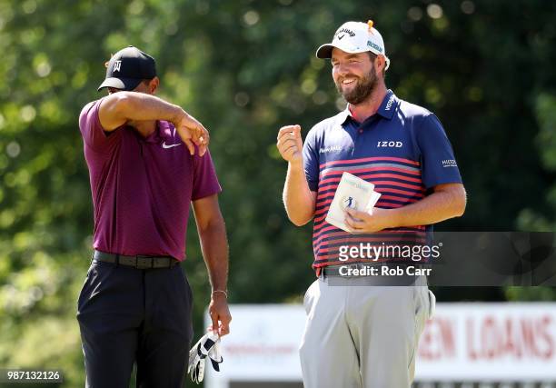 Tiger Woods and Marc Leishman of Australia speak on the 18th green during the second round of the Quicken Loans National at TPC Potomac on June 29,...