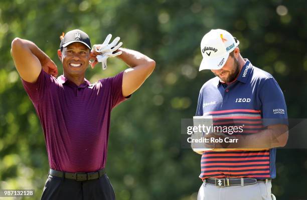 Tiger Woods and Marc Leishman of Australia speak on the 18th green during the second round of the Quicken Loans National at TPC Potomac on June 29,...