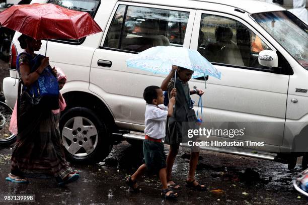 Children protest themselves during a rain, on June 28, 2018 in Mumbai, India. Heavy rains made a comeback in Mumbai causing waterlogging in many...