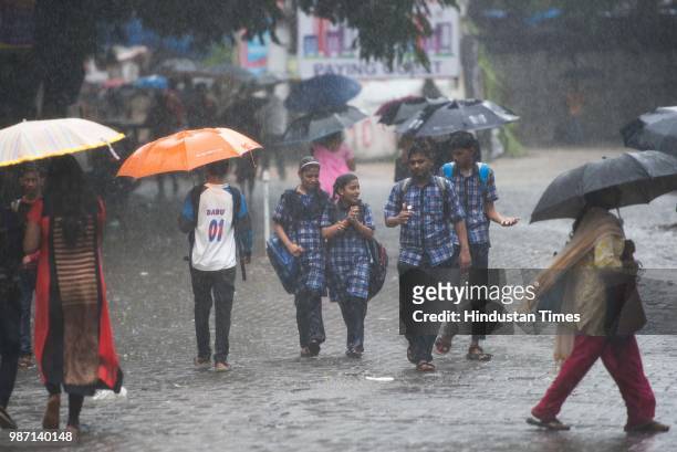 School children get drenched in rain at Bhandup, on June 28, 2018 in Mumbai, India. Heavy rains made a comeback in Mumbai causing waterlogging in...