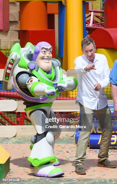 Actor Tim Allen and Disney character Buzz Lightyear pose "The Toy Story Land" preview at Disney's Hollywood Studios on June 29, 2018 in Orlando,...