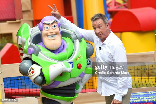 Actor Tim Allen and Disney character Buzz Lightyear pose "The Toy Story Land" preview at Disney's Hollywood Studios on June 29, 2018 in Orlando,...