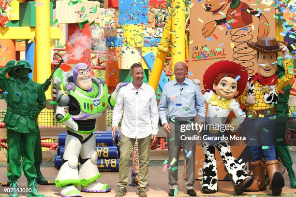 Actor Tim Allen and Disney Parks Chairman Robert A. Chapek pose with Disney characters during "The Toy Story Land" grand opening at Disney's...