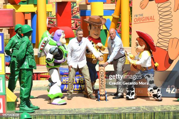 Actor Tim Allen and Disney Parks Chairman Robert A. Chapek pose with Disney characters during "The Toy Story Land" grand opening at Disney's...