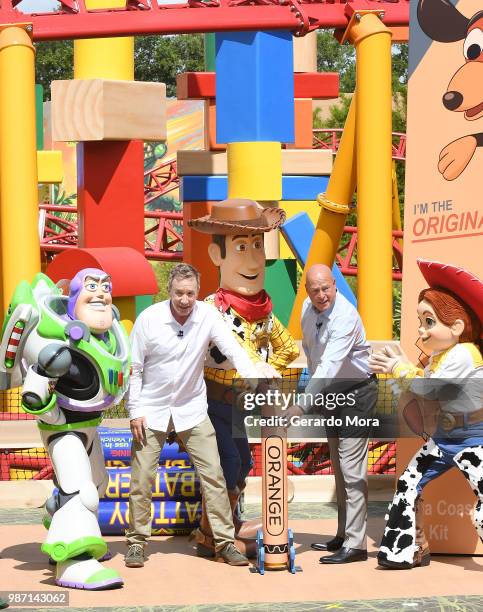 Actor Tim Allen and Disney Parks Chairman Robert A. Chapek pose with Disney characters during "The Toy Story Land" grand opening at Disney's...