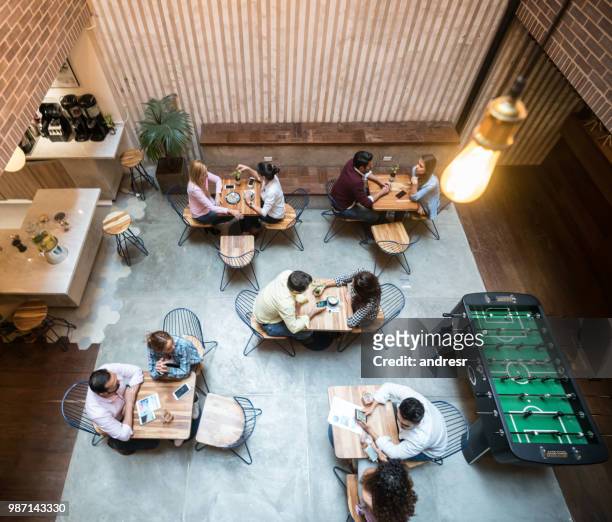 group of people at a cafe - coworking spaces stock pictures, royalty-free photos & images