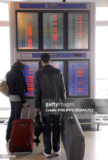 Passengers look at information boards announcing the cancelled flights in red, on April 20, 2010 at the Saint Exupery airport in Lyon, eastern...