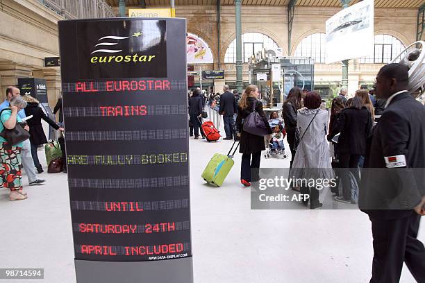 Passengers pass by an information board in Paris gare du Nord railway station, on April 20 to embark aboard a Eurostar to London. France railway...