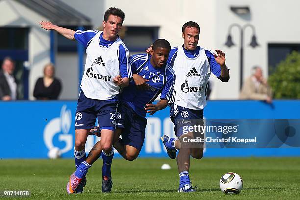 Christoph Moritz and Tore Reginiussen challenge Jefferson Farfan during the training session of FC Schalke at the training ground on April 28, 2010...