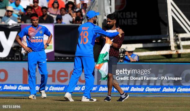 Virat Kholi of India ushers a spectator away after he invaded the pitch during the Second International Twenty20 Match at Malahide, Dublin.