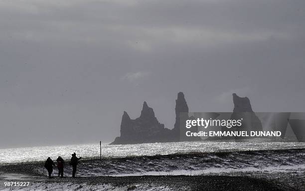 Tourists watch big rocks off Vik's coast, a village sitting at the base of the Myrdalsjokull glacier, which is part of the ice cap sealing the Katla...