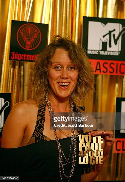 Comedian Clair Hooper holds a faux necklace reading "Vote Paul 4 Gold Logie" ahead of Sunday's Logie Awards as she arrives at the "MTV Classic: The...