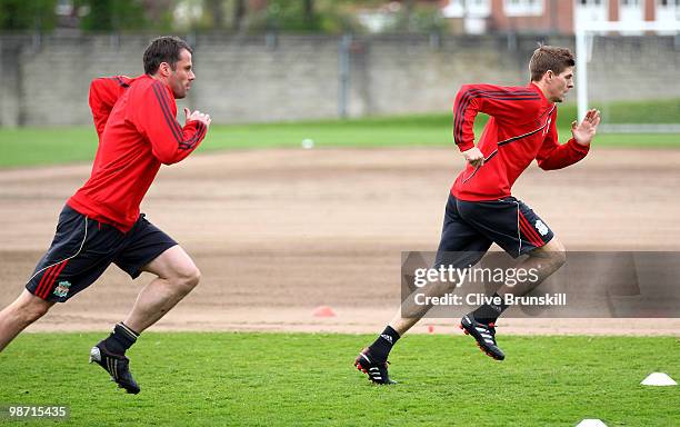 Steven Gerrard of Liverpool sprints away from team mate Jamie Carragher during a training session prior to the UEFA Europa League semi final second...