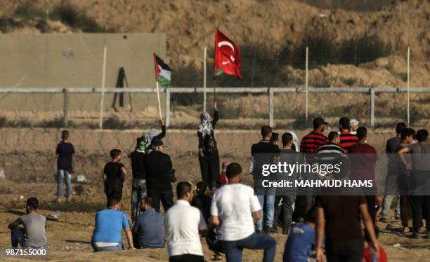 Women hold a Turkish and Palestinian flag during confrontation between Palestinian demonstrators and Israeli troops east of Gaza City, along the...