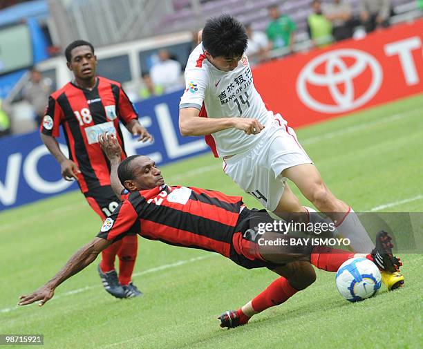 Indonesia's Persipura Jayapura player Ortizan Solossa fights for the ball with Chinese Changchun Yatai player Cao Tianbao during the AFC Champions...