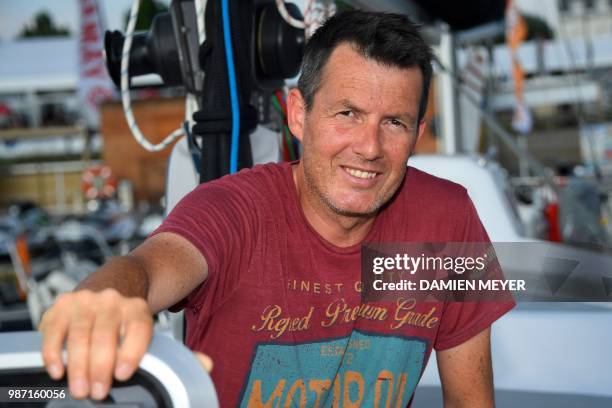 France's skipper Antoine Cousot poses on his boat "Metier Interim" in Les Sables d'Olonne Harbour, on June 29 ahead of the solo around-the-world...