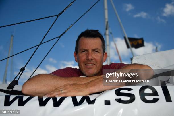 France's skipper Antoine Cousot poses on his boat "Metier Interim" in Les Sables d'Olonne Harbour, on June 29 ahead of the solo around-the-world...