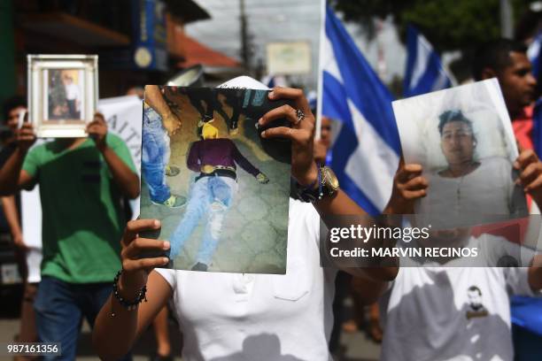 Protesters hold pictures of people killed during repression as they demand justice and the resignation of Nicaraguan President Daniel Ortega, at the...