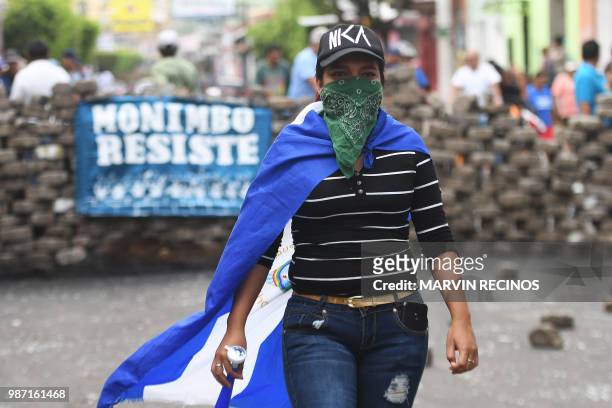 An anti-government demonstrator wrapped in a Nicaraguan national flag takes part in a protest demanding Nicaraguan President Daniel Ortega's...