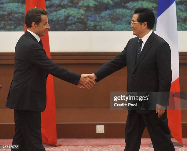 France's President Nicolas Sarkozy shakes hands with China's President Hu Jintao after a press conference at the Great Hall of the People on April...