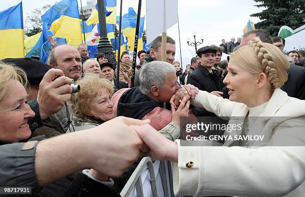 People shake hands with former Prime Minister of Ukraine Yulia Tymoshenko after a mass-meeting in front of the Ukrainian Parliament in Kiev on April...