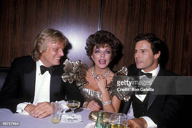 Actress Joan Collins, boyfriend Peter Holm and actor Michael Nader attend the 1983 Carousel of Hope Ball to Benefit the Barbara Davis Center for...
