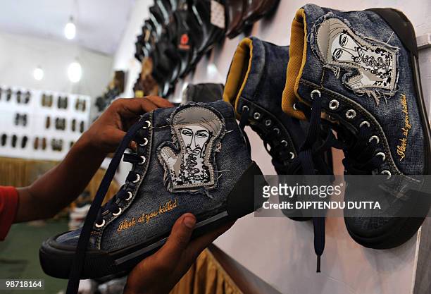 An Indian shopper selects shoes with a caricature of Osama Bin Laden at a shop in Allahabad on April 24, 2010. The Chinese-made shoes which bears the...