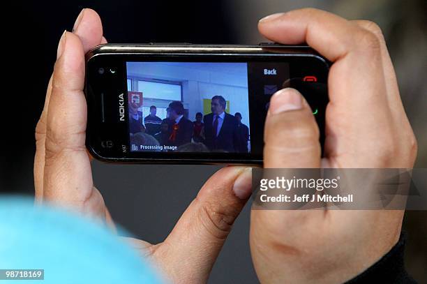 Woman takes a picture of Prime Minister Gordon Brown as he campaigns at a Honeywell community centre on April 28, 2010 in Oldham, England. The...