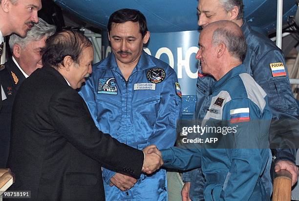 Algerian President Abdelaziz Bouteflika shakes hands with US commercial space tourist Dennis Tito , as Russian cosmonauts Talgat Musabayev and Yuri...