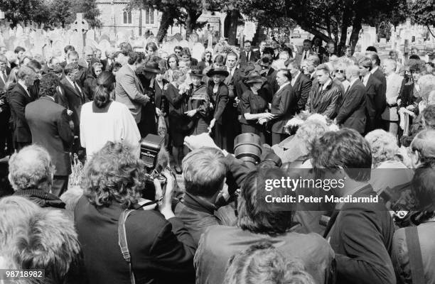Press photographers and mourners at the funeral of English career criminal Charlie Wilson, Wandsworth, London, 10th May 1990. Wilson was best known...