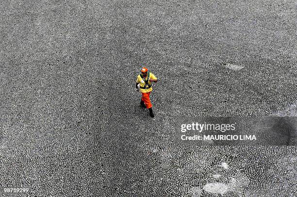 Street sweeper walks alone at the 'Vale do Anhangabau' area, in downtown Sao Paulo, Brazil, on September 21, 2009. Street sweepers have started a...