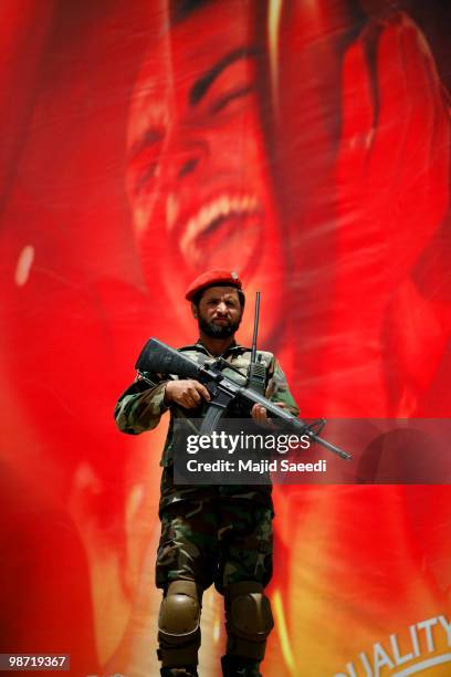 Member of the Afghan National Army stands guard in front of a commercial banner during a ceremony to commemorate the anniversary of the fall of a...