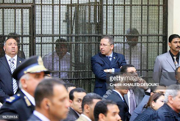 Egyptian tycoon Hisham Talaat Mustafa and retired policeman Mohsen al-Sukkari stand behind bars during their trial in the murder of Lebanese singer...