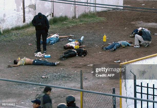 Police officers place markers next to the bodies of several men killed by drug traffickers in the bar in Ciudad Juarez, Mexico, on April 28, 2010....