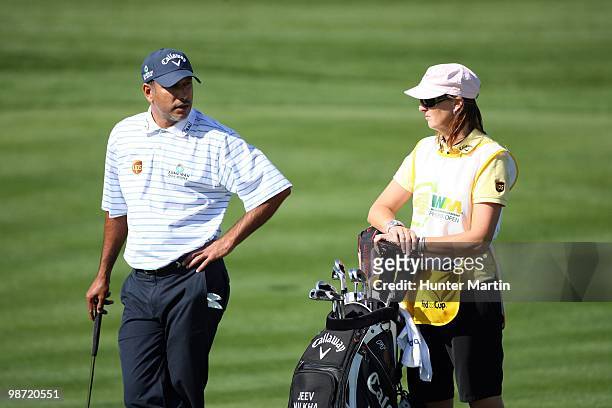 Jeev Milkha Singh talks with his caddie during the second round of the Waste Management Phoenix Open at TPC Scottsdale on February 26, 2010 in...